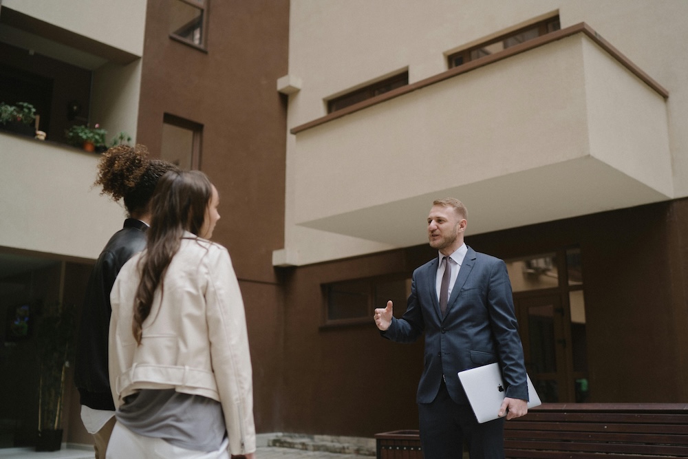 Real Estate Agent Showing a Property to Two People